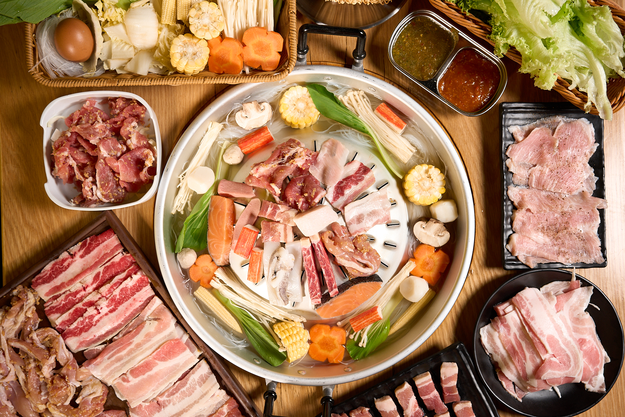 A Kin Tub mookata spread: sliced pork belly, marbled beef, prawns, vegetables and the charcoal pan